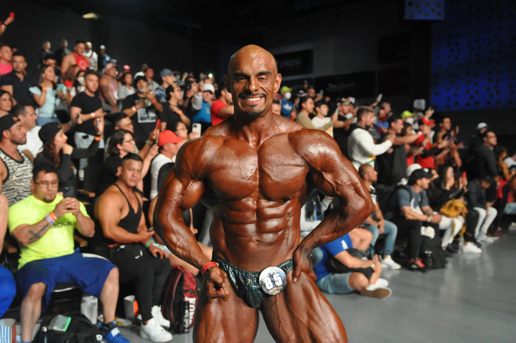 Bodybuilder posing on stage in front of a full crowd